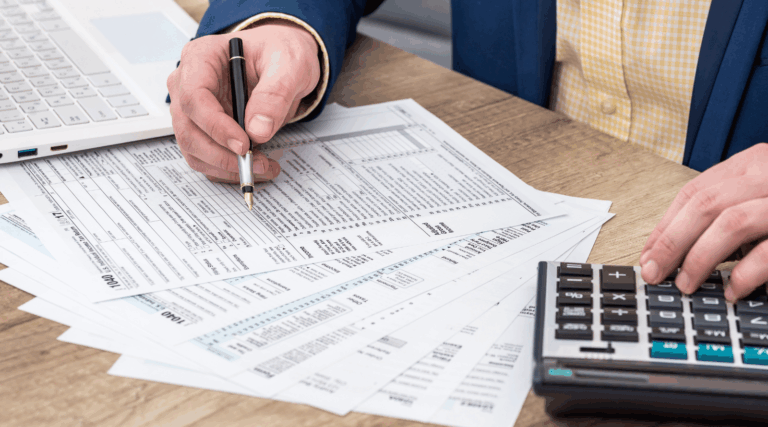 Businessman works with tax form, laptop and calculator